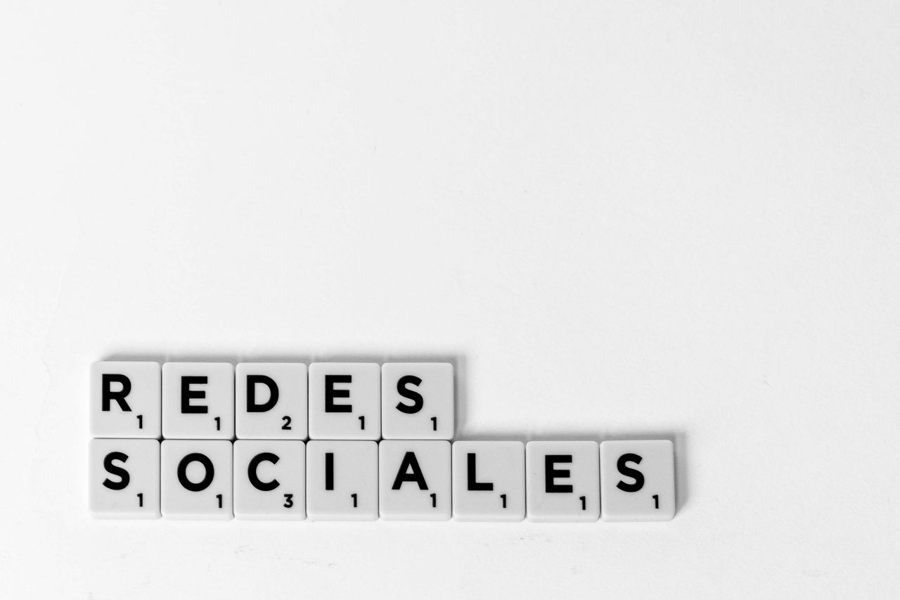 Services Scrabble tiles spelling 'Redes Sociales' illustrating a social media concept on a white background.