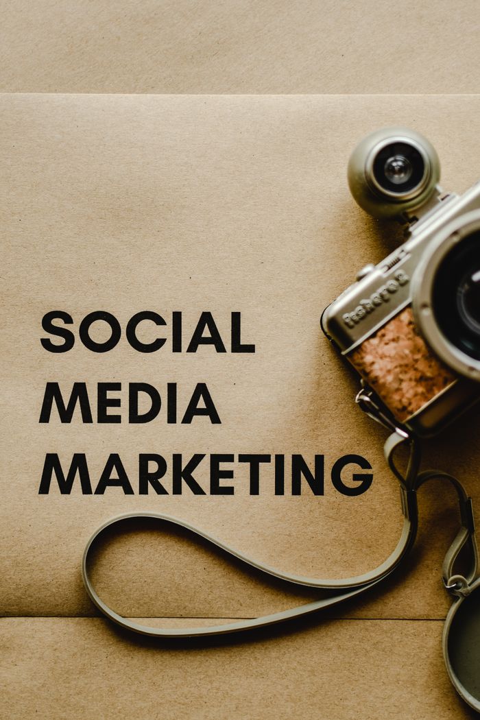 Services Close-up of a vintage camera next to a social media marketing concept text on a brown background.